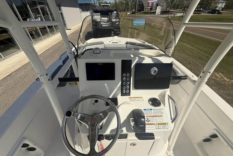 Slide: The Image of 2023 NauticStar 211 Hybrid boat dashboard with steering wheel and control panel. - 5