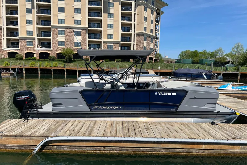 Slide: The Image of 2026 Starcraft GX 22 R DH boat docked at marina, with Mercury engine and modern design. - 1