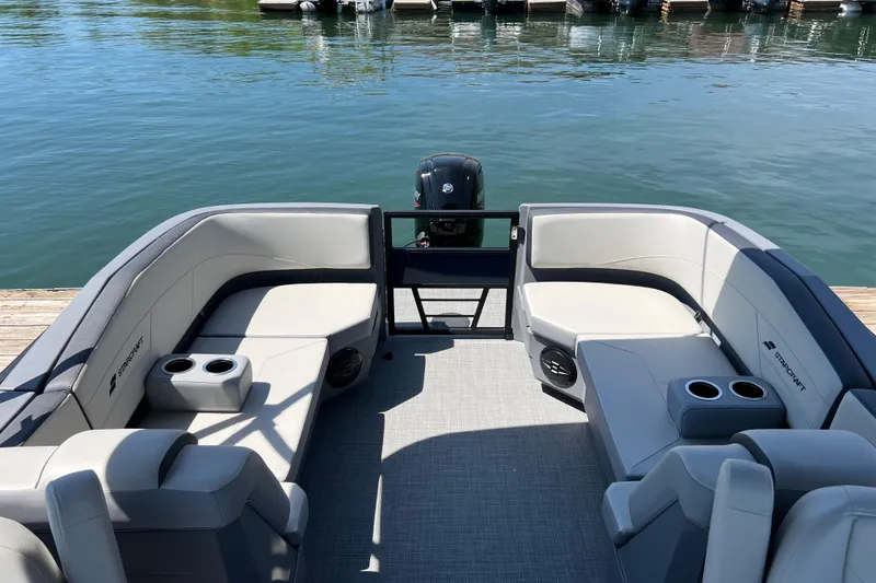 Slide: The Image of 2026 Starcraft GX 22 R DH boat interior with plush seating and cup holders by the water. - 12