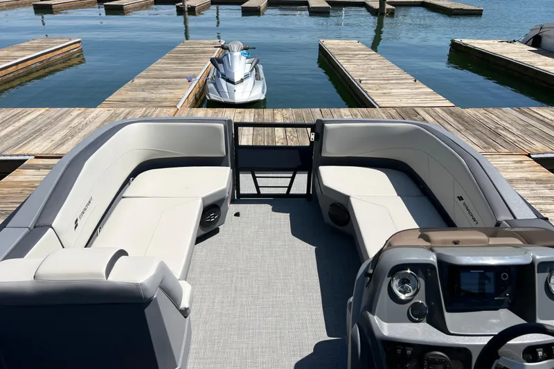 Slide: The Image of 2026 Starcraft GX 22 R DH boat interior with spacious seating at a marina dock. - 3