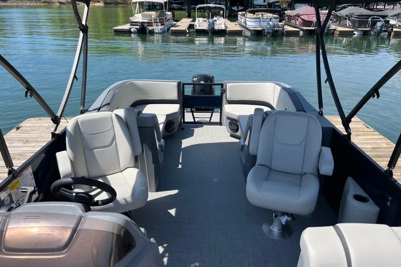 Slide: The Image of 2026 Starcraft GX 22 R DH boat interior with plush seating, docked by a serene lake. - 5