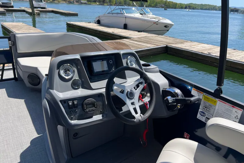 Slide: The Image of Helm of 2026 Starcraft GX 22 R DH boat at dockside, featuring modern controls and steering. - 8