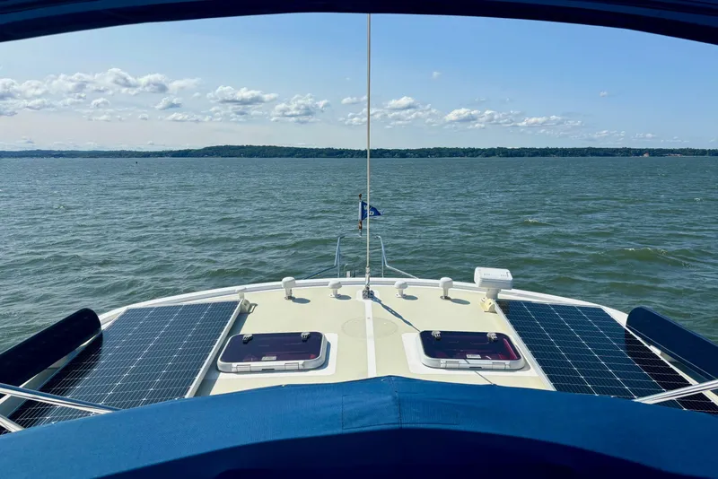 Slide: The Image of 2009 Kadey-Krogen boat with solar panels on deck, cruising on a calm lake. - 19