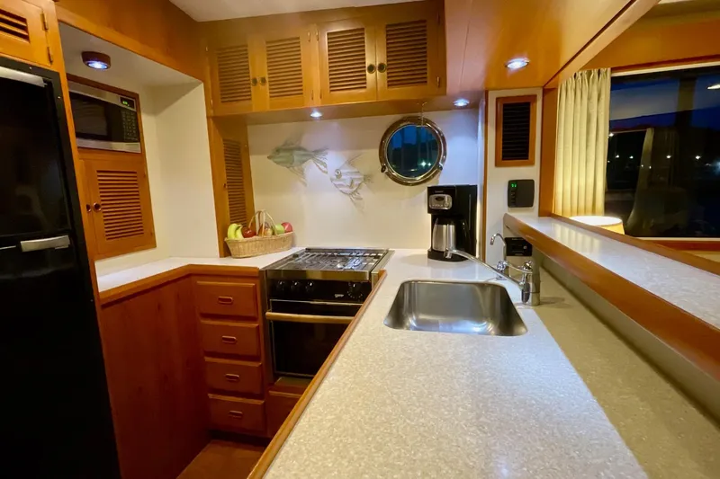 Slide: The Image of Luxurious 2009 Kadey-Krogen yacht kitchen with modern appliances and wooden cabinetry. - 7