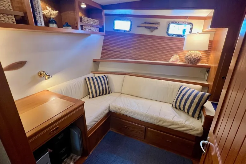 Slide: The Image of Cozy 2009 Kadey-Krogen yacht interior with cushioned seating, striped pillows, and wooden accents. - 8