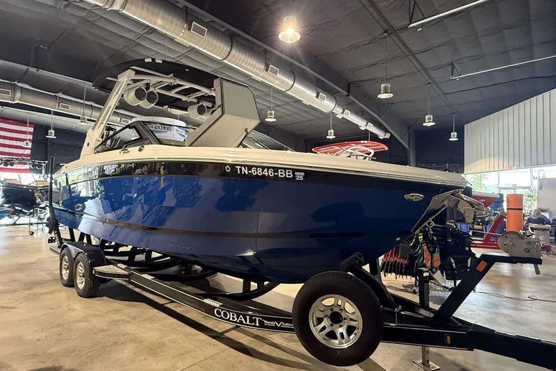 Slide: The Image of 2024 Cobalt R8 Surf boat in showroom, blue exterior, on trailer. - 18