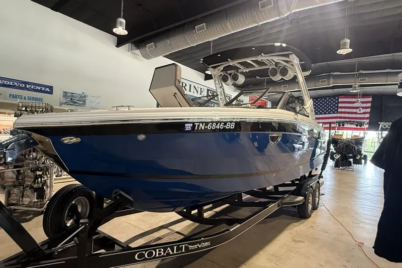 Slide: The Image of 2024 Cobalt R8 Surf boat in showroom, blue exterior, on trailer. - 19