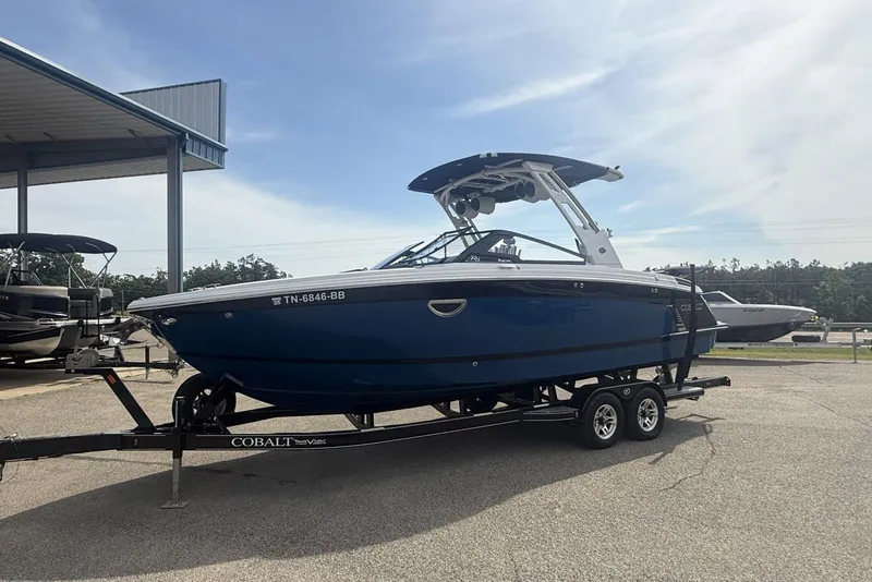 Slide: The Image of 2024 Cobalt R8 Surf boat on trailer, parked outdoors under clear sky. - 7