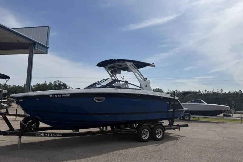 Slide: The Image of 2024 Cobalt R8 Surf boat on trailer under clear sky. - 8