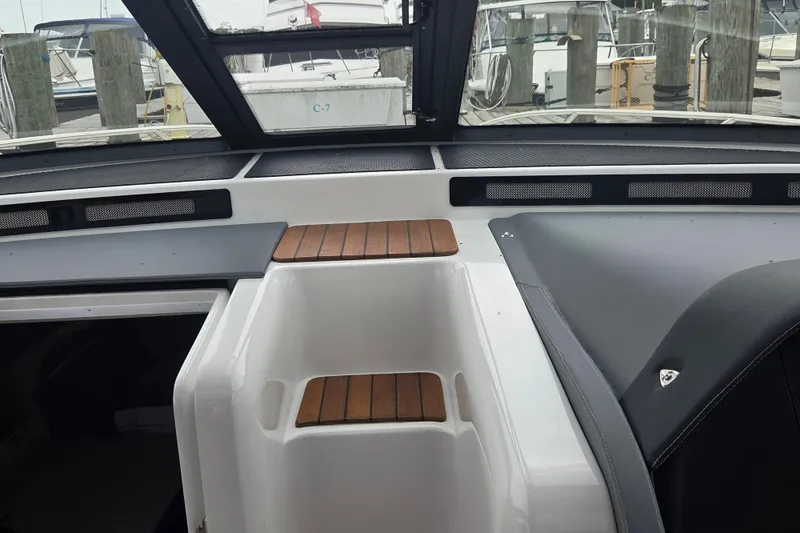 Slide: The Image of 2017 Cobalt A40 Coupe interior with wooden accents and docked boats in background. - 25