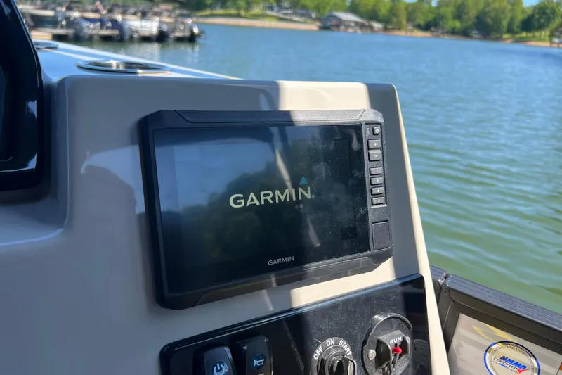 Slide: The Image of Garmin display on 2026 Manitou 23 Aurora LE RF boat, with lake view in background. - 10