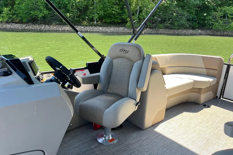 Slide: The Image of Interior of 2026 Manitou 23 Aurora LE RF boat with plush seating and steering console. - 14