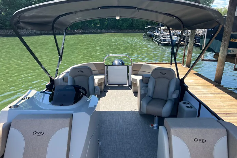 Slide: The Image of 2026 Manitou 23 Aurora LE RF pontoon boat with canopy on a serene lake. - 4