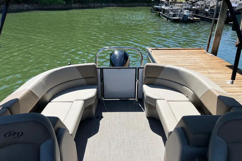Slide: The Image of 2026 Manitou 23 Aurora LE RF pontoon boat interior with plush seating and lake view. - 5