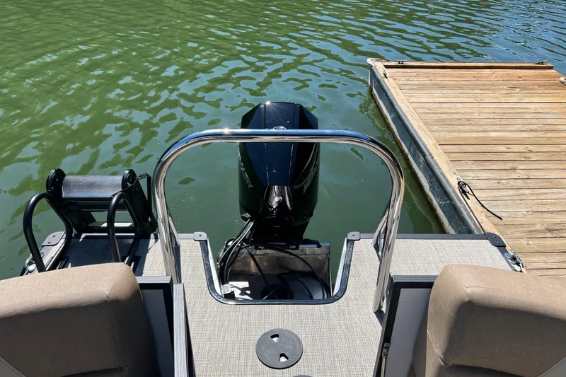 Slide: The Image of 2026 Manitou 23 Aurora LE RF boat at dock, rear view with motor. - 6