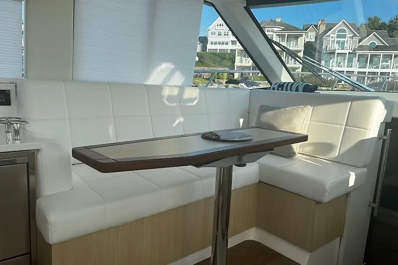 Slide: The Image of Interior of 2024 Regal 38 Grande Coupe with white seating and wooden table. - 12