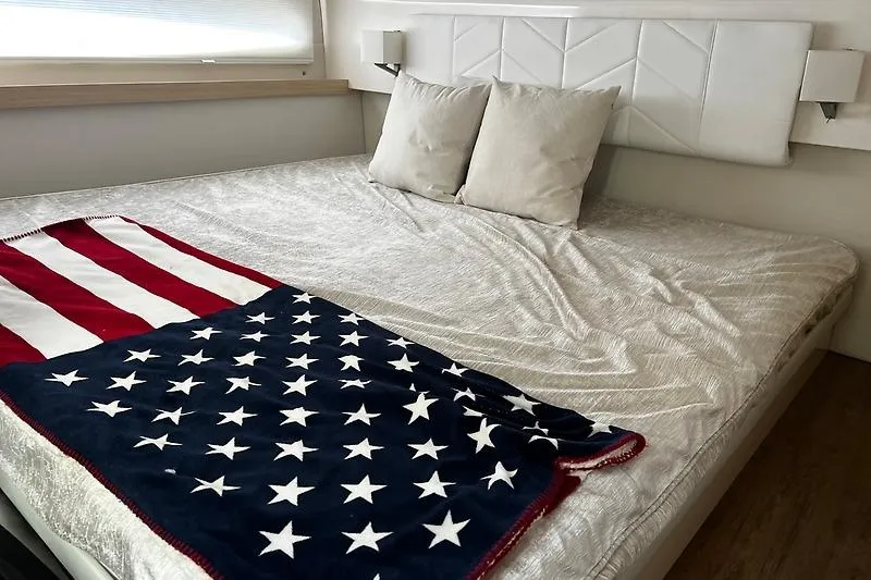 Slide: The Image of Luxurious bed in 2024 Regal 38 Grande Coupe with American flag blanket. - 20