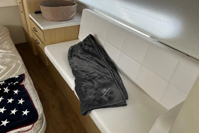 Slide: The Image of Interior of 2024 Regal 38 Grande Coupe with white seating and cozy blanket. - 21