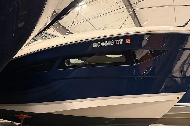 Slide: The Image of 2024 Regal 38 Grande Coupe boat in a showroom, showcasing sleek blue hull design. - 28
