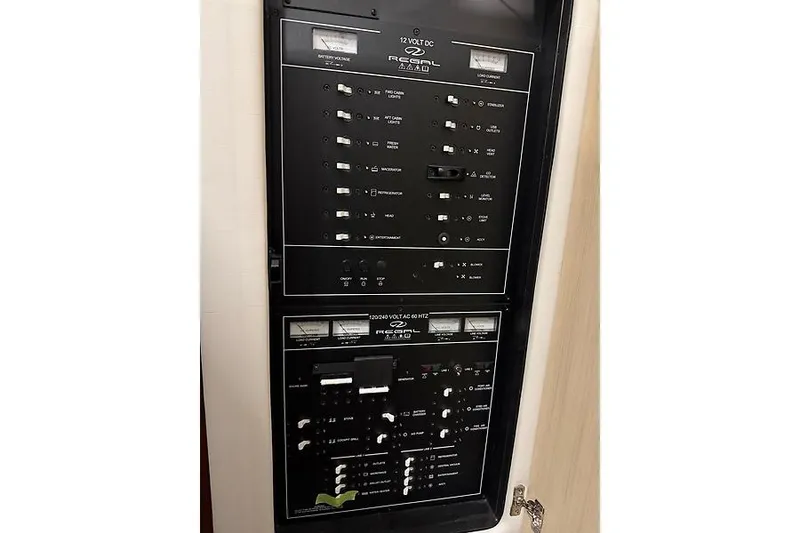 Slide: The Image of Electrical control panel of 2024 Regal 38 Grande Coupe yacht, featuring switches and gauges. - 32