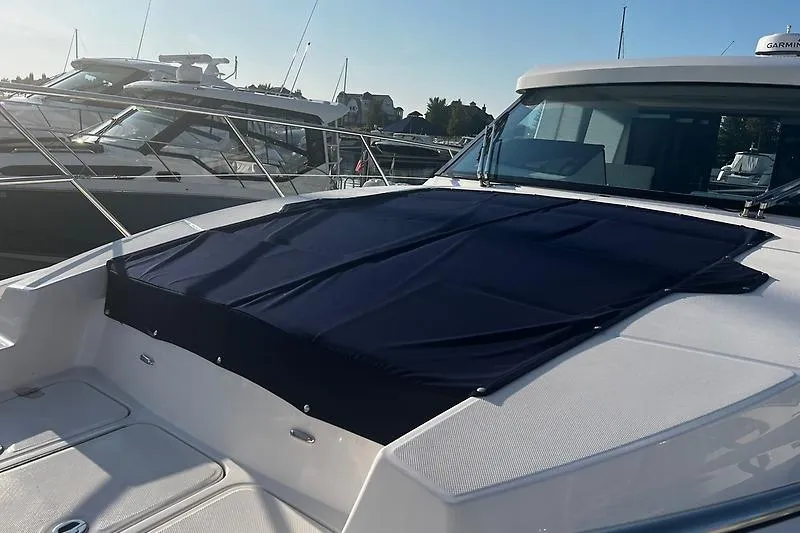 Slide: The Image of 2024 Regal 38 Grande Coupe yacht with covered deck in marina setting. - 5