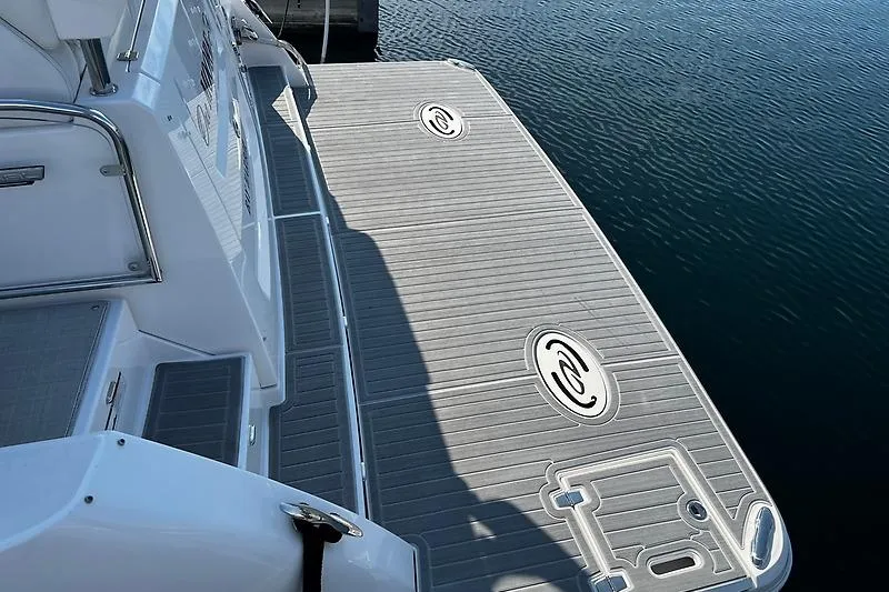 Slide: The Image of 2024 Regal 38 Grande Coupe swim platform with sleek design on calm water. - 6