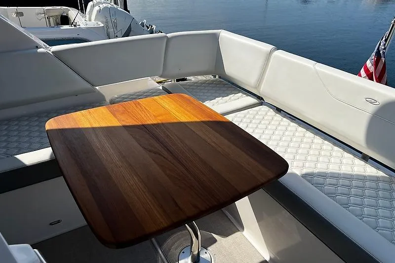 Slide: The Image of Luxurious seating area on 2024 Regal 38 Grande Coupe yacht with wooden table. - 7