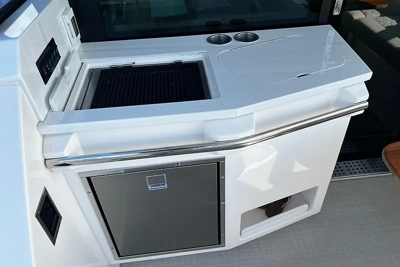 Slide: The Image of Outdoor kitchen on 2024 Regal 38 Grande Coupe yacht with grill and storage. - 9
