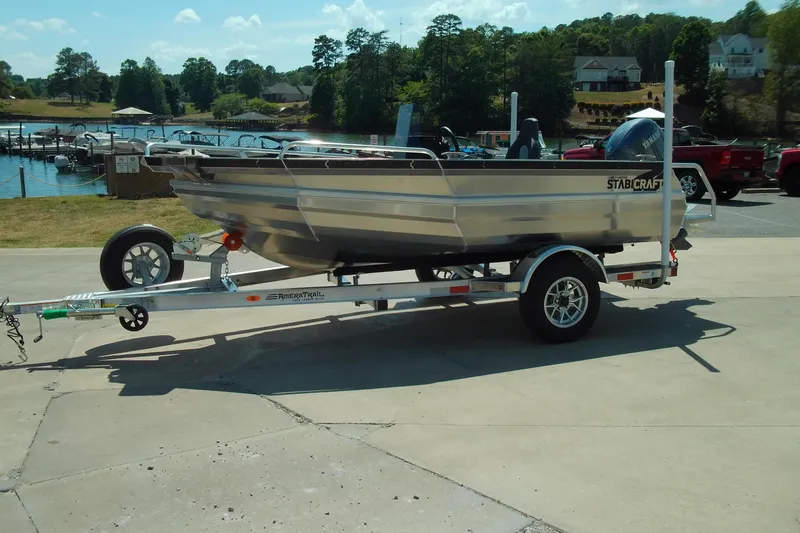 The Image of 2026 Stabicraft 1450 Frontier boat on trailer by a scenic lakeside. - 1