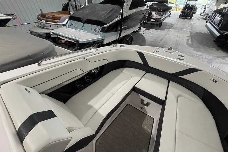Slide: The Image of 2016 Regal 24 FasDeck RX boat interior with sleek white seating in a showroom. - 14