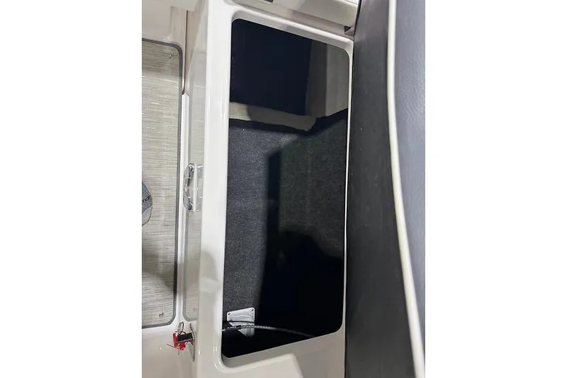 Slide: The Image of Storage compartment of a 2016 Regal 24 FasDeck RX boat, featuring a sleek interior design. - 30
