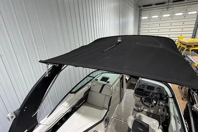 Slide: The Image of 2016 Regal 24 FasDeck RX boat with black canopy in storage. - 7