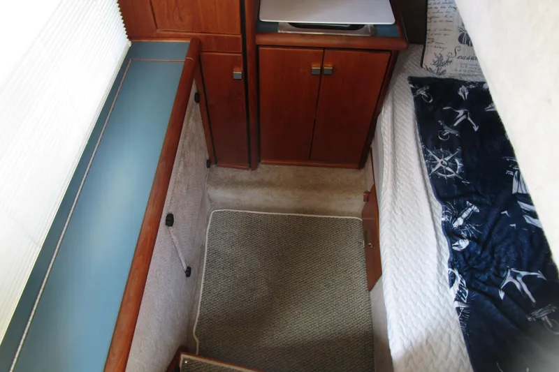 Slide: The Image of 1989 Bayliner 3288 Motoryacht interior cabin with wood cabinetry and nautical-themed bedding. - 16