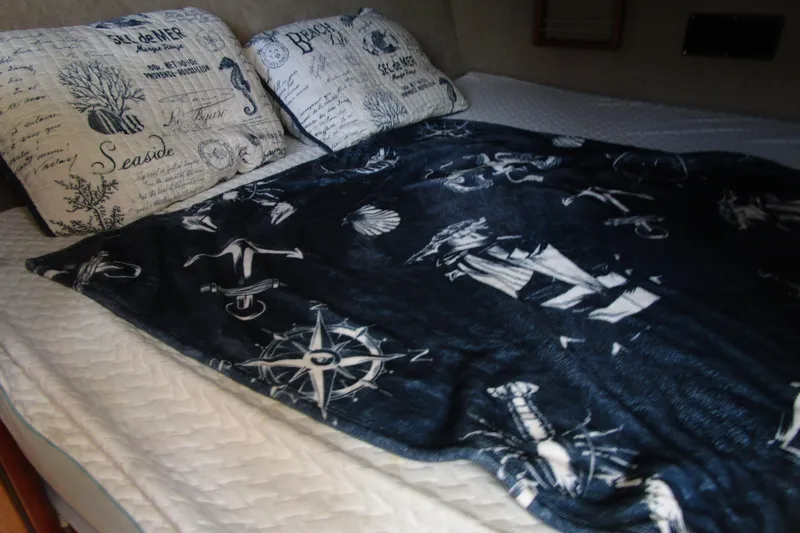 Slide: The Image of Cozy bed in 1989 Bayliner 3288 Motoryacht with nautical-themed bedding and pillows. - 17