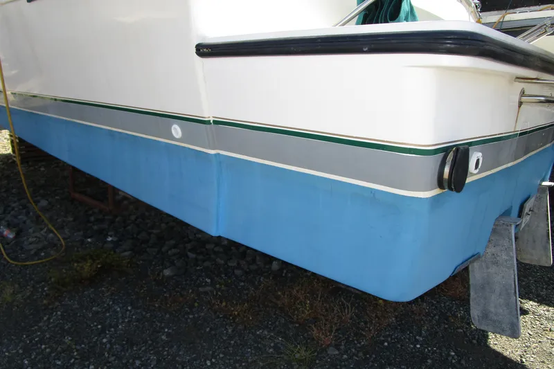 Slide: The Image of 1989 Bayliner 3288 Motoryacht hull with blue and white exterior on dry dock. - 3