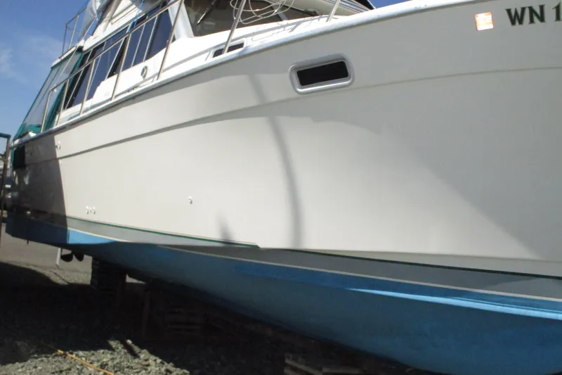 Slide: The Image of 1989 Bayliner 3288 Motoryacht on dry dock, showcasing sleek white hull and blue bottom. - 4