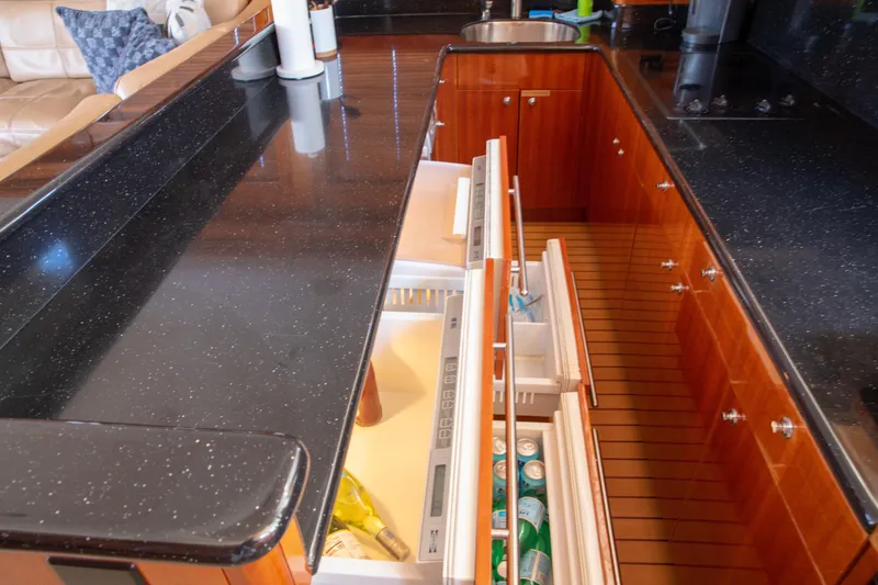 Slide: The Image of Luxurious kitchen area on a 2002 Hatteras 63 Raised Pilothouse Motor Yacht with open drawers. - 36