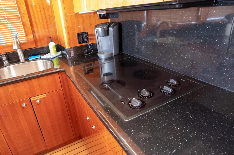 Slide: The Image of Luxurious kitchen in 2002 Hatteras 63 Yacht with sleek black countertop and modern appliances. - 38