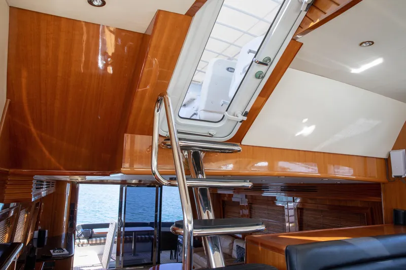 Slide: The Image of Interior of 2002 Hatteras 63 Raised Pilothouse Motor Yacht with polished wood and metal staircase. - 48