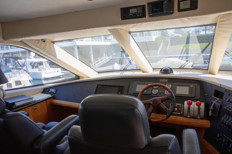 Slide: The Image of Pilothouse interior of 2002 Hatteras 63 Raised Pilothouse Motor Yacht, featuring navigation controls and seating. - 50