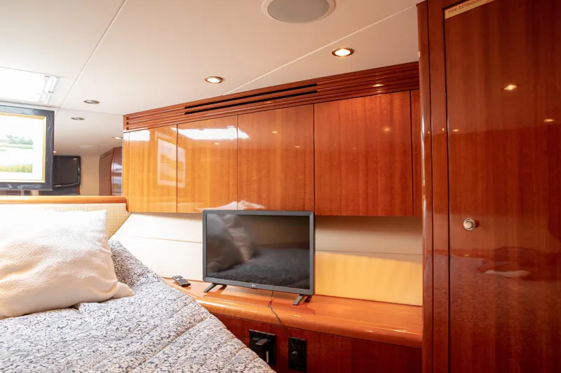 Slide: The Image of Luxurious cabin interior of 2002 Hatteras 63 Raised Pilothouse Motor Yacht with TV and wood paneling. - 61