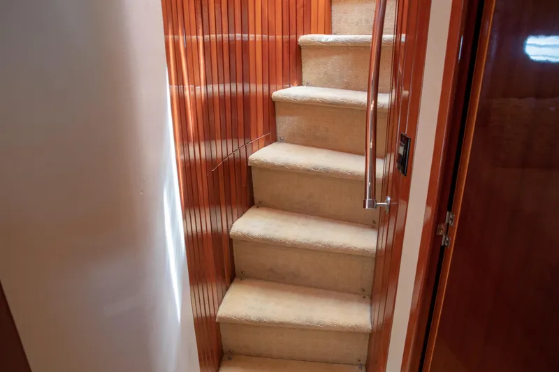 Slide: The Image of Staircase inside 2002 Hatteras 63 Raised Pilothouse Motor Yacht with wooden paneling. - 66