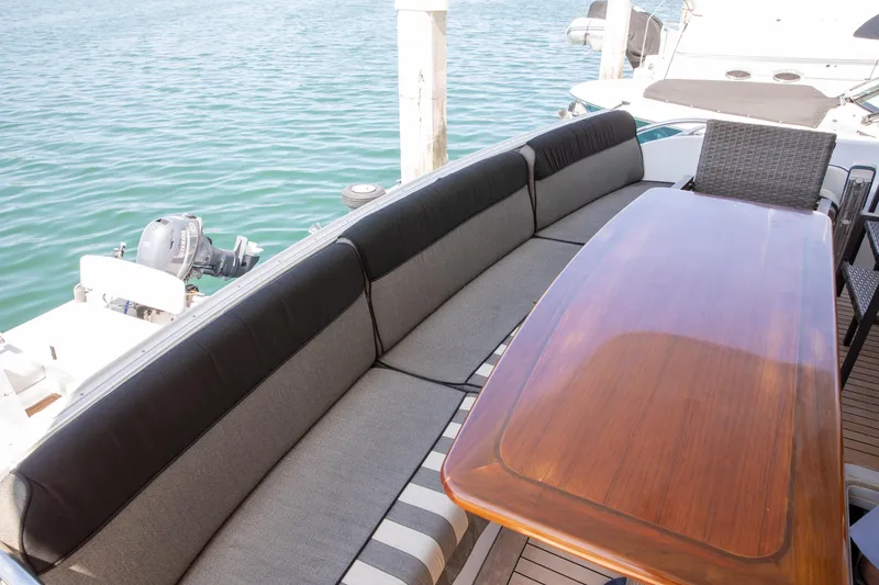 Slide: The Image of Outdoor seating area on 2002 Hatteras 63 Raised Pilothouse Motor Yacht, featuring a wooden table. - 68