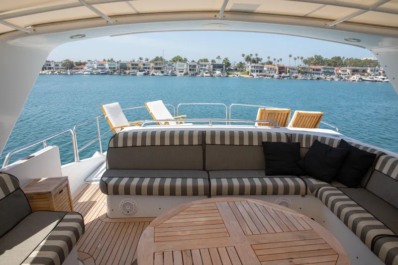 Slide: The Image of Luxurious 2002 Hatteras 63 Yacht with elegant seating and scenic waterfront view. - 69