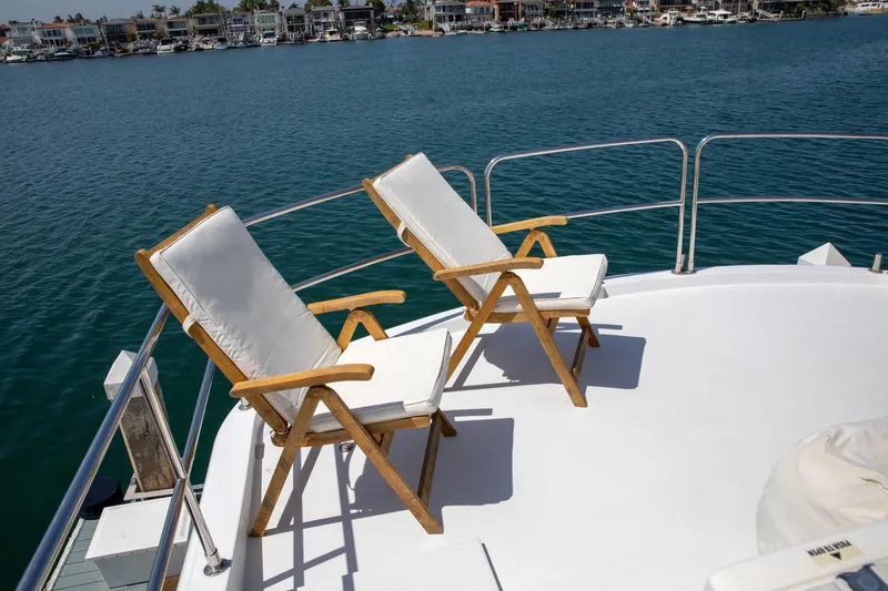 Slide: The Image of Two cushioned chairs on the deck of a 2002 Hatteras 63 Motor Yacht. - 71