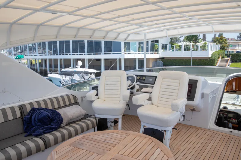 Slide: The Image of Luxurious 2002 Hatteras 63 Raised Pilothouse Motor Yacht helm with plush seating and modern controls. - 72