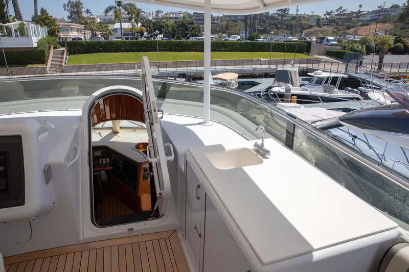 Slide: The Image of 2002 Hatteras 63 Raised Pilothouse Motor Yacht with open hatch and marina view. - 80