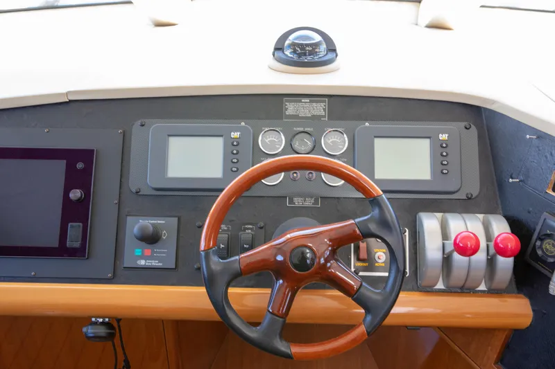Slide: The Image of Pilothouse of 2002 Hatteras 63 Raised Motor Yacht with steering wheel and control panels. - 84