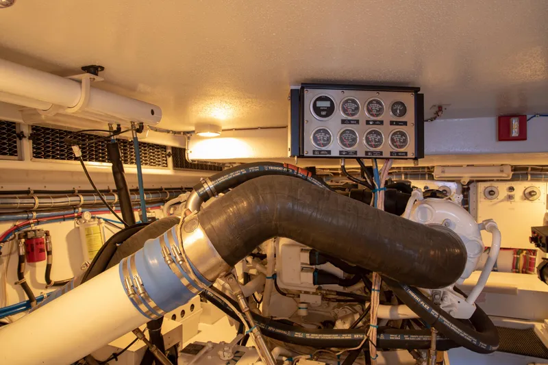 Slide: The Image of Engine room of 2002 Hatteras 63 Raised Pilothouse Motor Yacht with control panel and piping. - 94