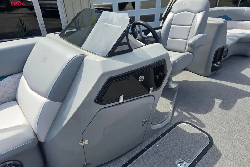 Slide: The Image of Interior view of 2022 Manitou 23 Encore RF boat with sleek dashboard and seating. - 10
